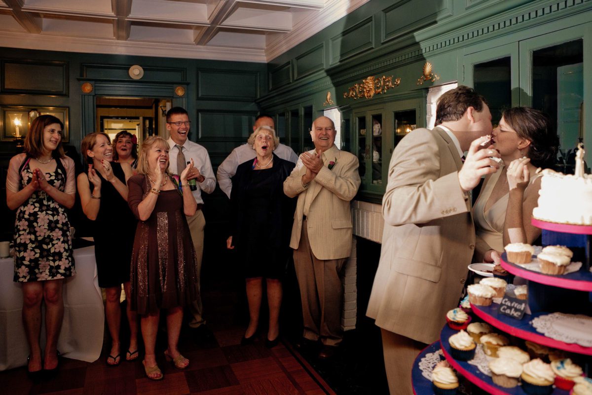 Classic Wedding at Tarrywile Mansion groom kises bride with frosting lips while guests clap