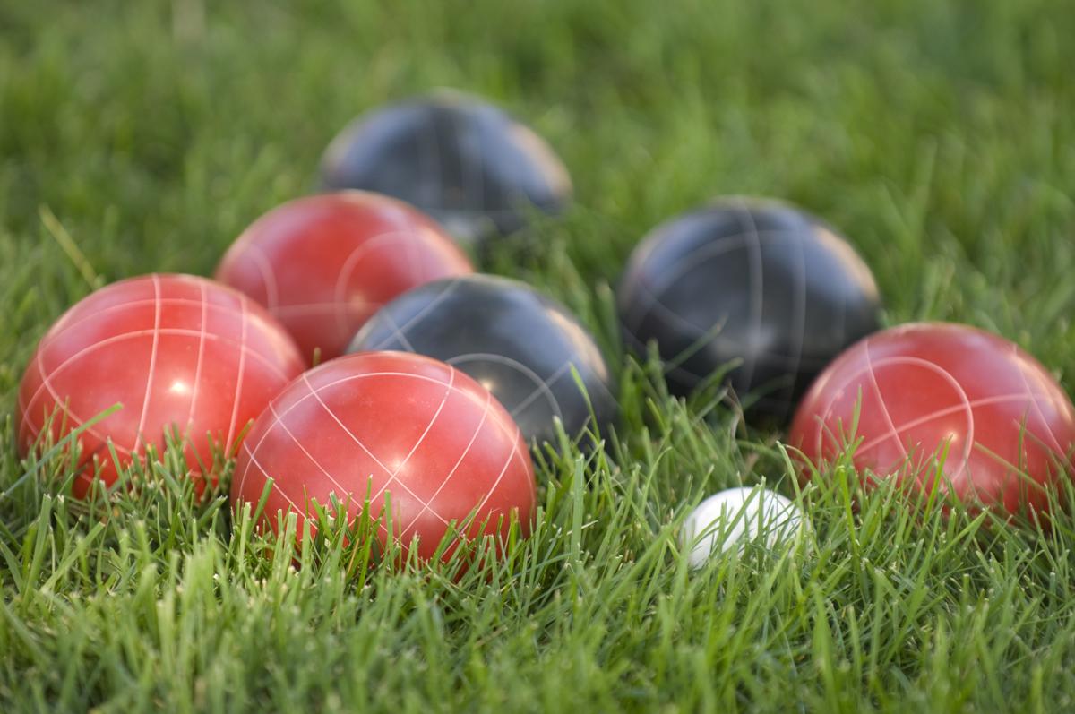 blue and red bocce balls in grass