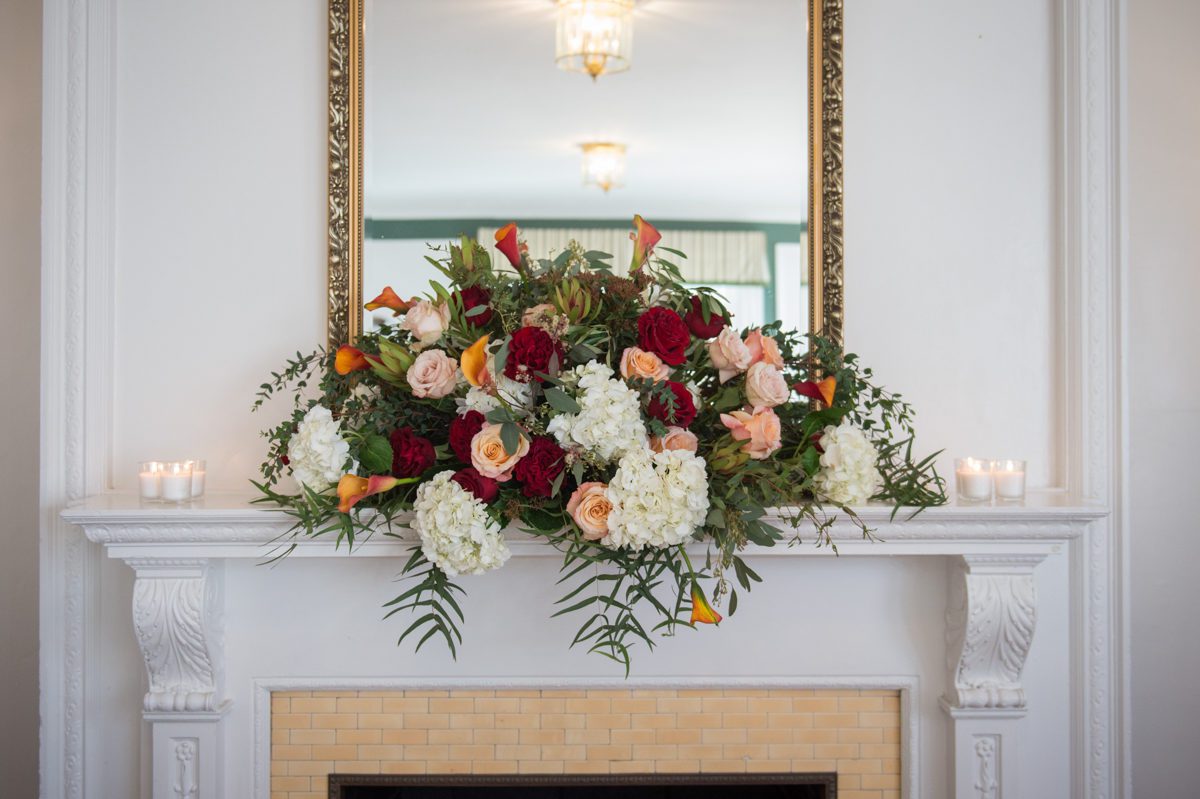 large floral arrangement on the fireplace mantle