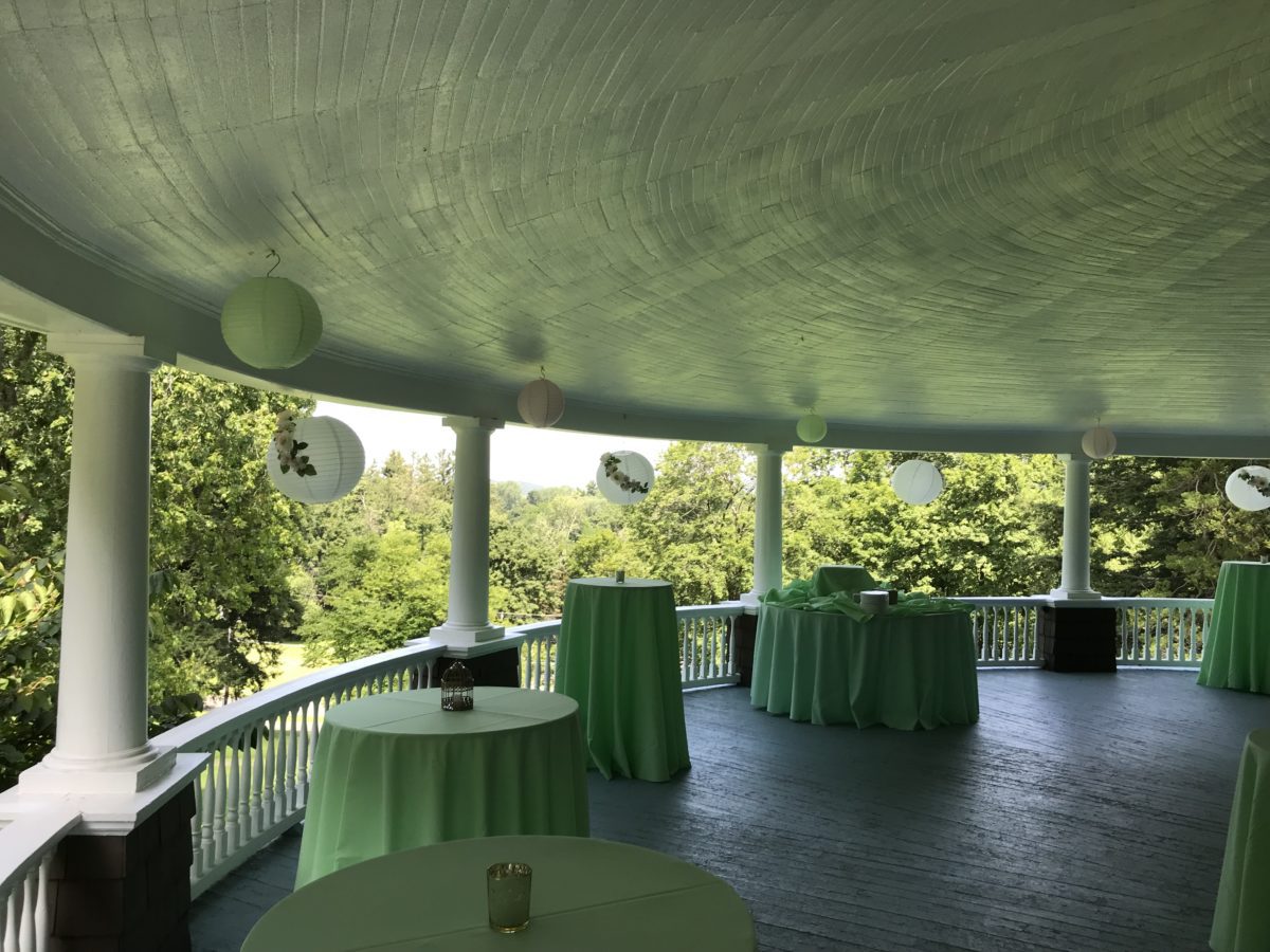 tables set up on veranda with green lanterns and linens