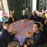 fundraising-volunteers-sitting-around-table-eating-with-bunny-ears-on